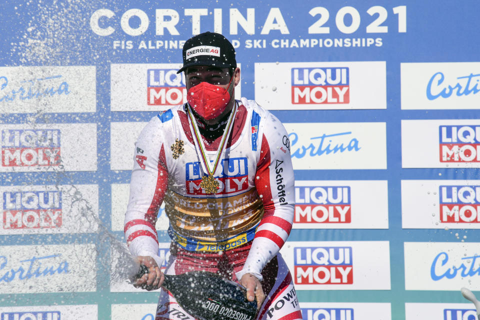Austria's Vincent Kriechmayr sprays sparkling wine on the podium as he celebrates after winning the men's downhill, at the alpine ski World Championships in Cortina d'Ampezzo, Italy, Sunday, Feb.14, 2021. (AP Photo/Giovanni Auletta)