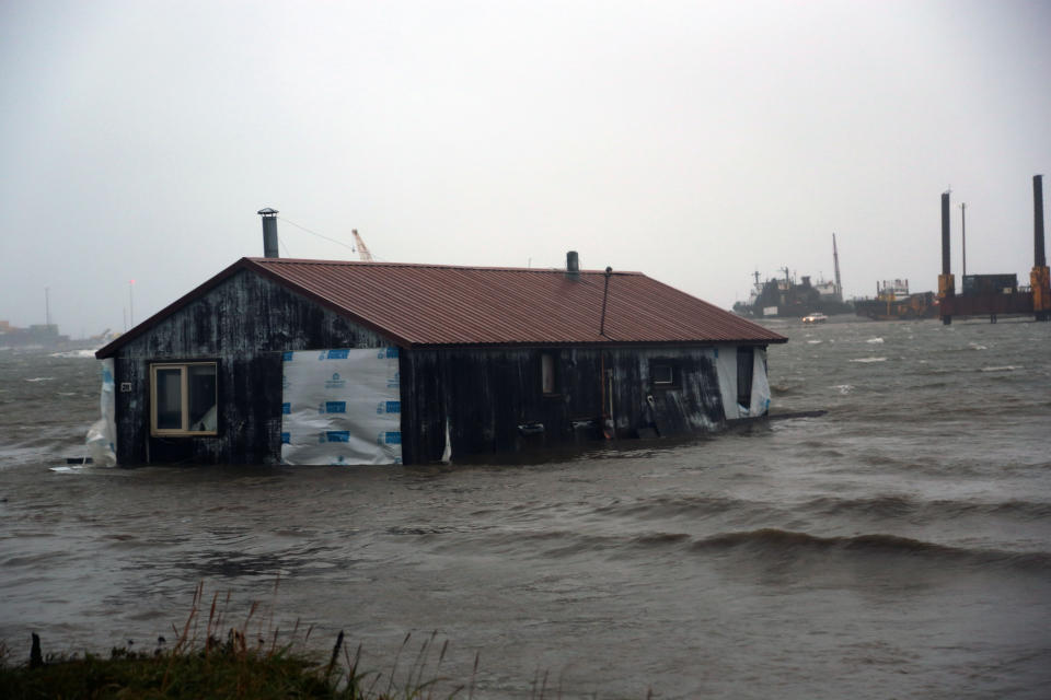 FILE - A house floats in the Snake River near Nome, Alaska, Sept. 17, 2022, after the remnants of Typhoon Merbok moved into the Bering Sea region. Gov. Mike Dunleavy toured the devastated area this week and he is seeking a federal disaster declaration to help those affected by the storm. (AP Photo/Peggy Fagerstrom, File)