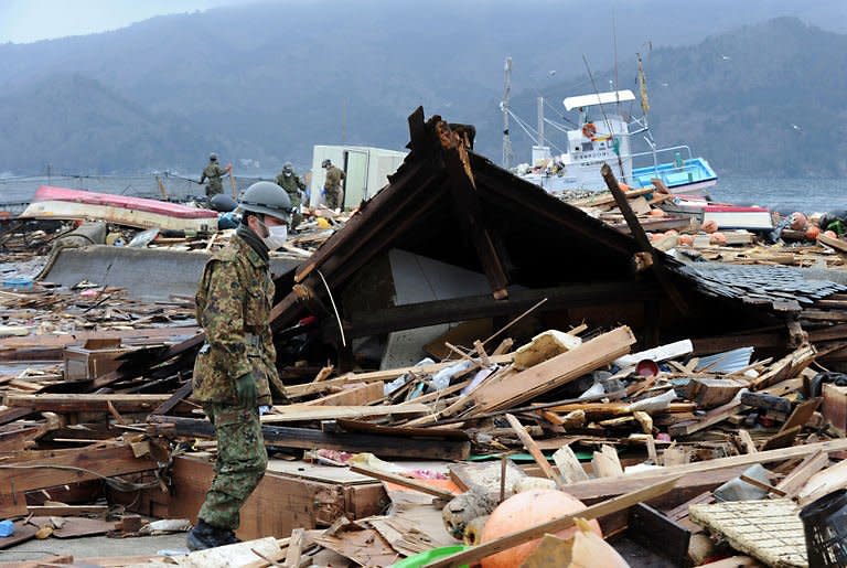 Japanese Self-Defense Force soldiers search for the missing in a small village beside the Onagawa nuclear plant in Onagawa in Miyagi prefecture. Smoke belched from a stricken nuclear plant in Japan on Monday, disrupting urgent efforts to repair the cooling systems as Tokyo halted some food shipments owing to radiation worries