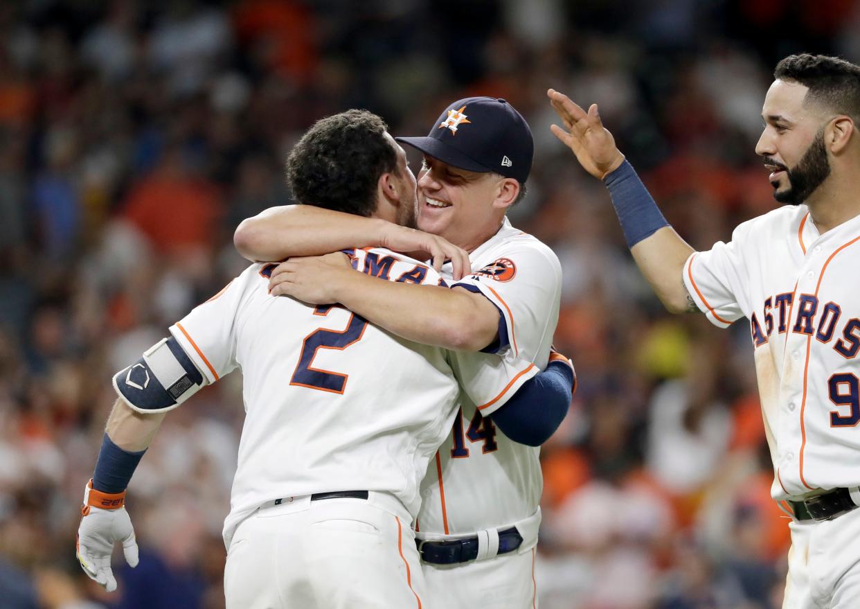 Houston Astros manager AJ Hinch (14) hugs Alex Bregman (2) after Bregman hit a game-winning double to score two runs against the Tampa Bay Rays during the ninth inning of a baseball game Monday, June 18, 2018, in Houston. The Astros won 5-4. (AP Photo/David J. Phillip)