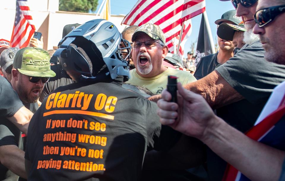 Black Lives Matter protesters and counter protesters clash in Yorba Linda, Calif., Saturday, Sept. 26, 2020. Police eventually declared the event an unlawful gathering and cleared the streets near Yorba Linda and Imperial. Authorities said people were struck by a car and injured during a Black Lives Matter protest and counter-protest about 30 miles southeast of Los Angeles. Orange County Sheriff's Department spokeswoman Carrie Braun says the injured were transported to a hospital with non-life-threatening injuries and the driver was detained. (Mindy Schauer/The Orange County Register via AP)