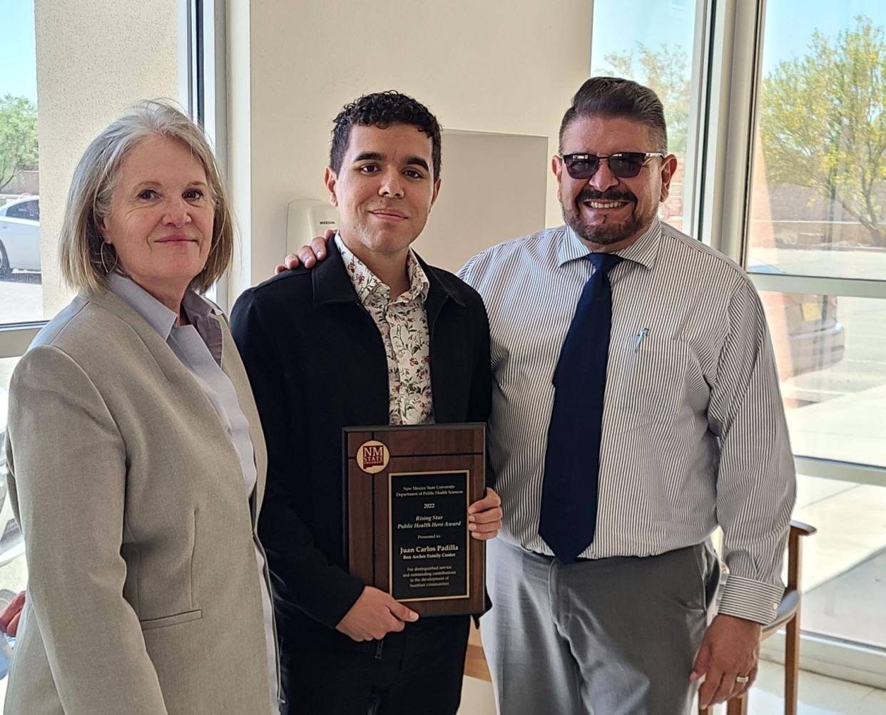 Juan Carlos Padilla of Ben Archer Health Center, center, receives the Rising Public Health Hero Award from New Mexico State University’s Department of Public Health Sciences. Padilla, an NMSU alumnus who recently earned a master’s degree in public health, stands with Frances Scappaticci, left, also of Ben Archer Health Center, and Héctor Luis Díaz, head of NMSU’s Department of Public Health Sciences.
