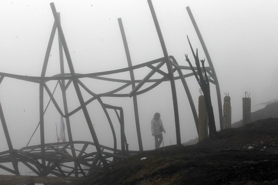 Una mujer camina entre los escombros de una de las casas destruidas por incendios en cerros de Valparaíso, Chle, el martes 15 de abril de 2014. Al menos 15 personas han perdido la vida y las llamas han arrasado más de 2.900 casas y dejado 12.500 damnificados. (Foto AP/Luis Hidalgo).
