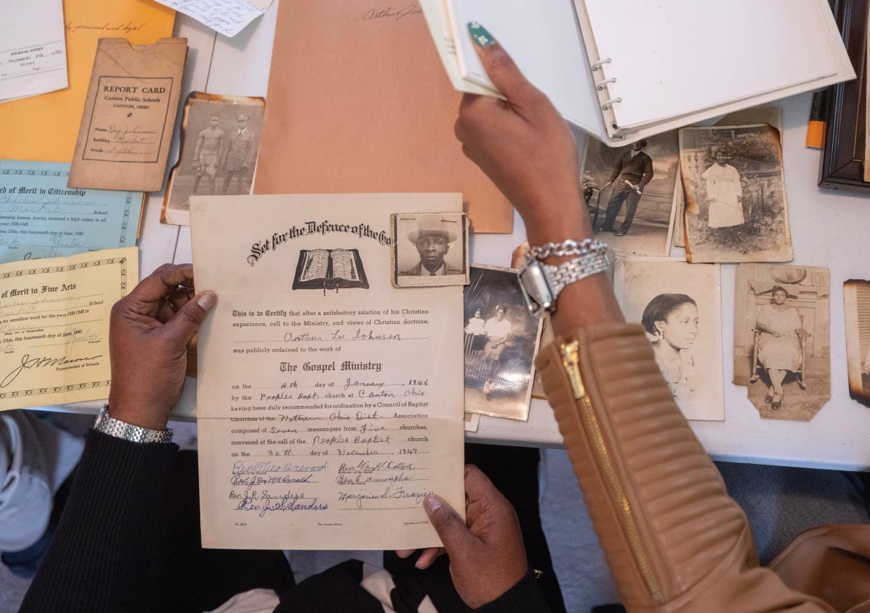 Deborah Johnson-Graham, left, and Kim Manley look over family photos and documents Habitat for Humanity found hidden away in their former family home in Canton.