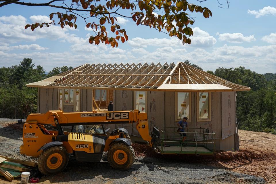 Workers build a home Tuesday, Sept. 19, 2023, in Marshall, N.C. Climate change is increasing billion-dollar disasters, many of them from intensifying hurricanes. Housing developers are now building homes, some of them round, that can resist hurricane-force winds and at the same time generate much less of the emissions that contribute to climate change. (AP Photo/Chris Carlson)