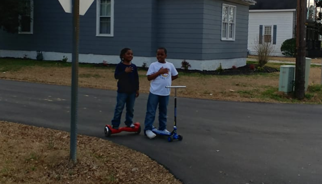 A moment captured by a chaplain is going viral. It shows two young people who stopped playing and said the Pledge of Allegiance as a flag was being raised at a fire department. (Photo: Facebook)