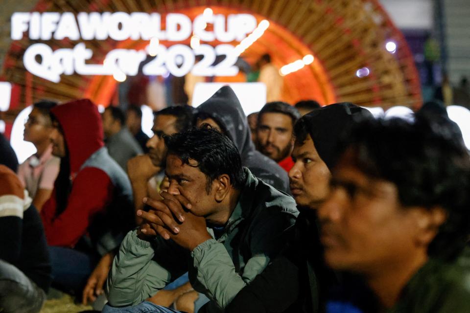 Qatar's migrant workers watch the Qatar 2022 World Cup Group E football match between Spain and Germany on November 27, 2022, at the Asian Town cricket stadium, on the outskirts of Doha. - The stadium has become a daily draw for thousands of the poorest workers who live in nearby dormitories away from Doha's glitzy shopping malls and restaurants. (Photo by David GANNON / AFP) (Photo by DAVID GANNON/AFP via Getty Images)