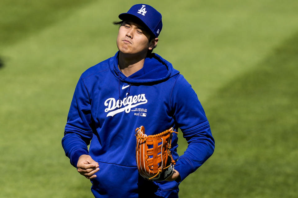 Los Angeles Dodgers' Shohei Ohtani reacts as he throws before a baseball game against the Washington Nationals at Nationals Park, Tuesday, April 23, 2024, in Washington. (AP Photo/Alex Brandon)