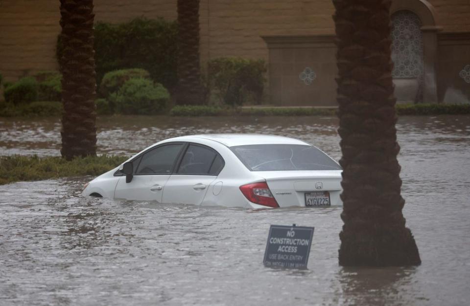 A car is partially submerged in floodwaters as Tropical Storm Hilary moves through Cathedral City, California, on Sunday.