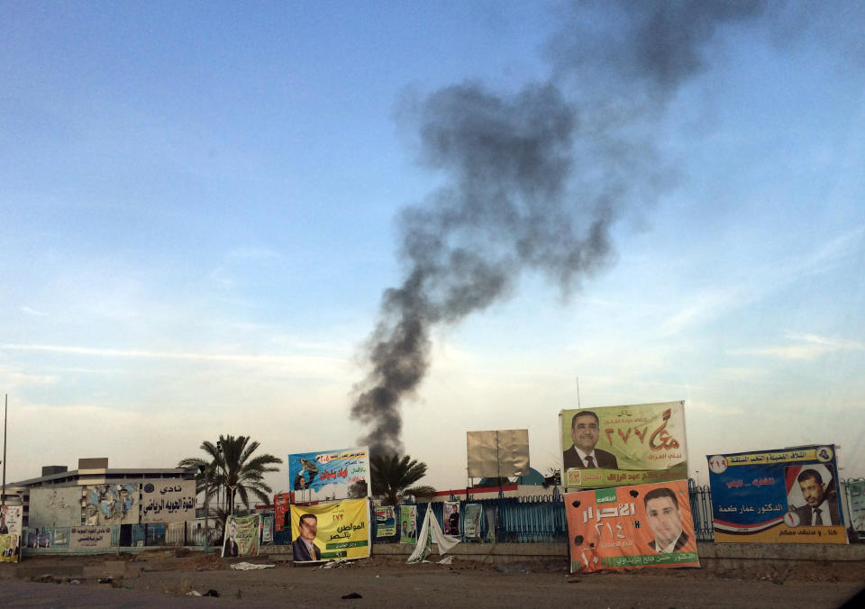 FILE - In this file photo taken Friday, April 25, 2014, smoke rises above campaign posters after a series of bombs that exploded at a campaign rally for a Shiite group in Baghdad, Iraq, ahead of the country's parliamentary election. As parliamentary elections are held Wednesday, April 30, more than two years after the withdrawal of U.S. troops, Baghdad is once again a city gripped by fear and scarred by violence. (AP Photo/Karim Kadim, File)