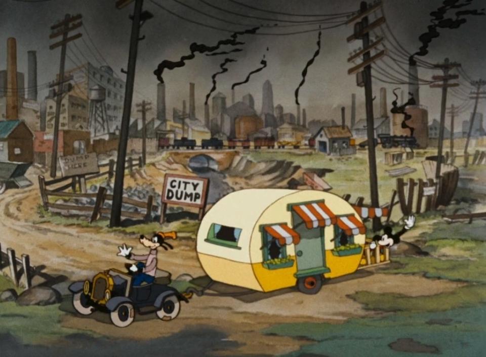 Goofy drives Mickey's trailer away from the city dump