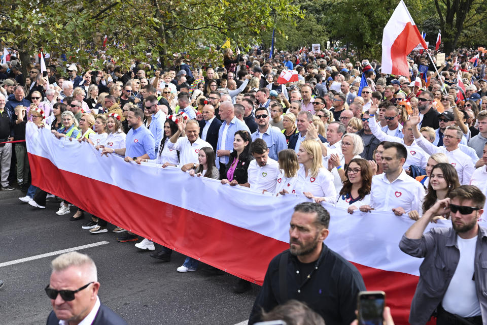 Opposition leader Donald Tusk, first row waving, leads a march to support the opposition against the governing populist Law and Justice party in Warsaw, Poland, Sunday, Oct. 1, 2023. Polish opposition leader Donald Tusk seeks to boost his election chances for the parliament elections on Oct. 15, 2023, leading the rally in the Polish capital. (AP Photo/Rafal Oleksiewicz)