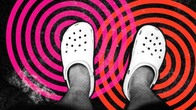 A person’s pair of feet wearing a pair of white Crocs shoes. The controversial shoe has regained popularity and garnered recognition in the footwear world, collaborating with big names and brands such as Justin Bieber, Balenciaga and Bad Bunny.