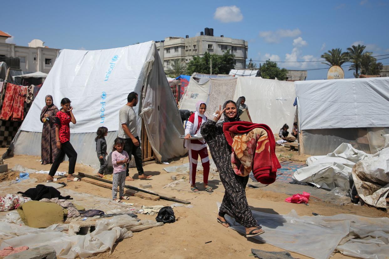 A Palestinian woman prepares to evacuate a tent camp after Israeli forces launch an operation in the eastern part of Rafah (REUTERS)