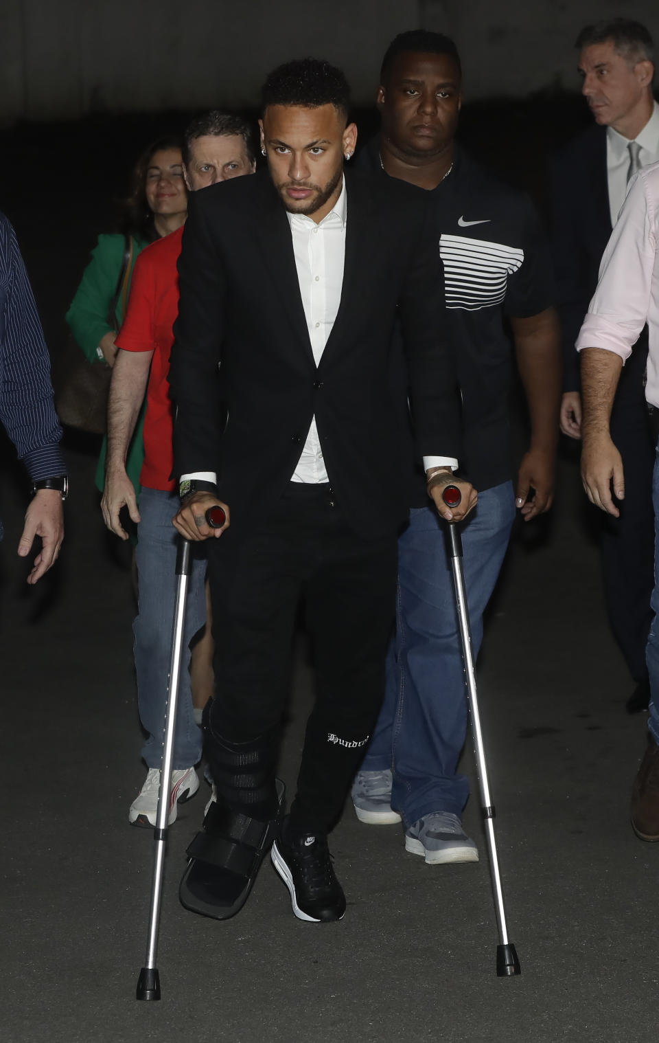 Using crutches because of an injured right ankle, Brazil's soccer player Neymar leaves a police station where he answered questions about rape allegations against him in Sao Paulo, Brazil, Thursday, June 13, 2019. Neymar denies any wrongdoing. (AP Photo/Andre Penner)