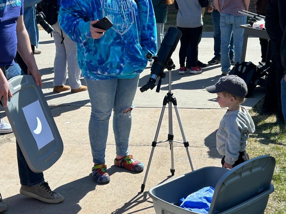 Lake Superior State University faculty show the eclipse shadow to a young community member on Monday, April 8.
