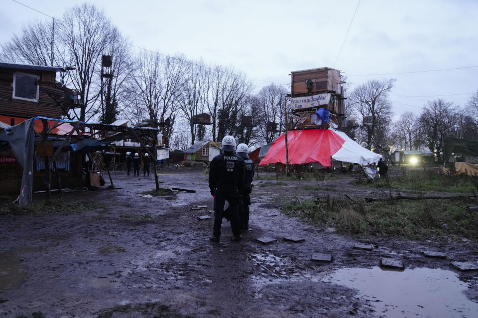 Police officers stand inside a camp of climate activists at the village Luetzerath, near Erkelenz, Germany, Thursday, Jan. 12, 2023. Police have entered the condemned village in to evict the climate activists holed up at the site in an effort to prevent its demolition, to make way for the expansion of a coal mine. (AP Photo/Michael Probst)