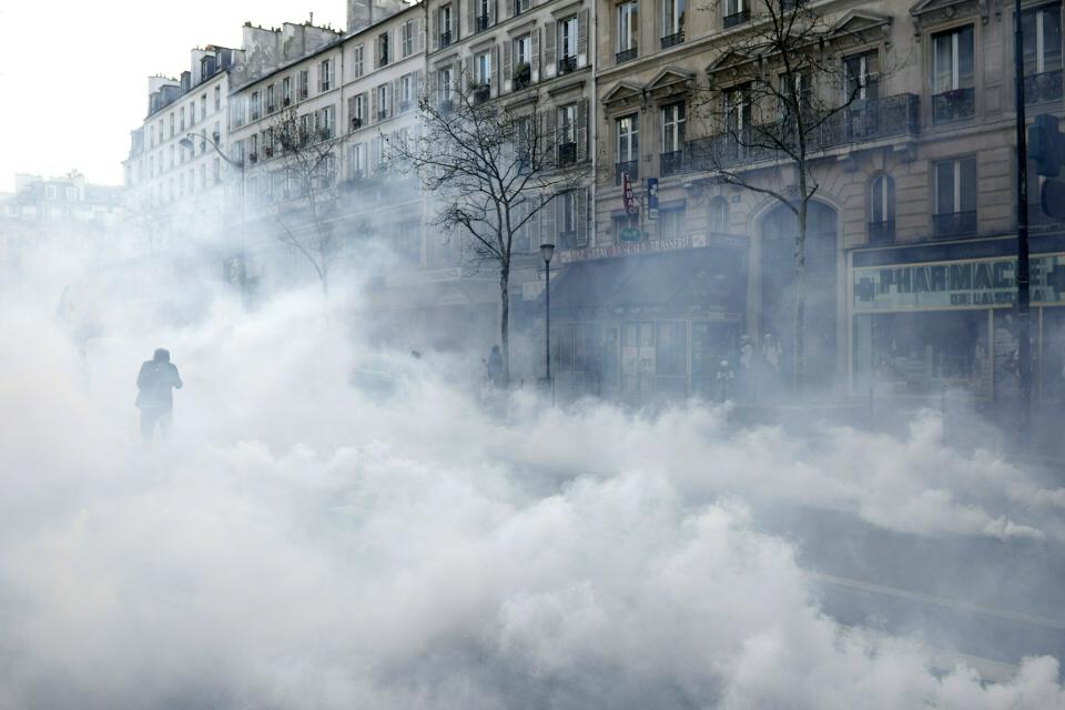 Una nube de gas lacrimógeno durante un enfrentamiento entre manifestantes y la policía en París, el sábado 23 de marzo de 2019. (AP Foto/Kamil Zihnioglu)