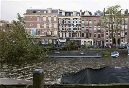 A tree lies fallen on a houseboat (C), sinking it, in a canal along the Jacob van Lennepkade street in Amsterdam October 28, 2013. REUTERS/Cris Toala Olivares