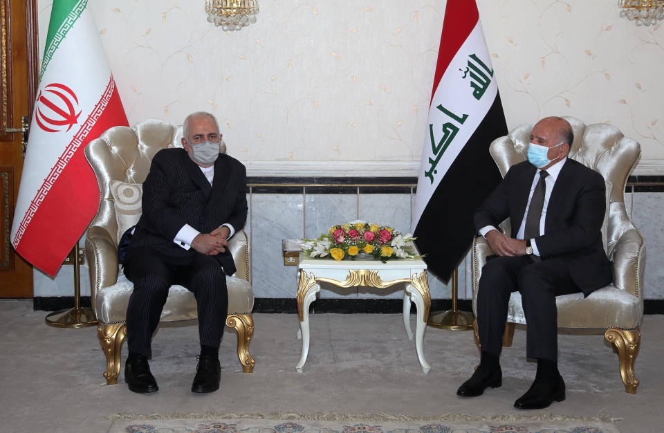 Iraqi Foreign Minister Fouad Hussein, right, meets with visiting Iranian counterpart Mohammad Javad Zarif in Baghdad, Iraq, Monday, April 26, 2021. (AP Photo/Khalid Mohammed)