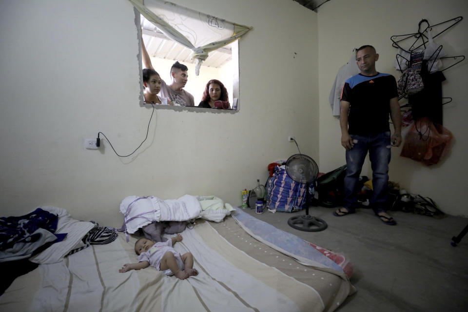 El inmigrante venezolano José Antonio Pulido, de pie junto a su hija de dos meses Zuleidys Antonella Primera, en su casa de Cúcuta, Colombia, el jueves 2 de mayo de 2019. (AP Foto/Fernando Vergara)