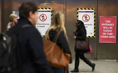 Travellers walk past the closed entrance to the Underground station at Waterloo during a strike by members of two unions in protest at ticket office closures and reduced staffing levels, in London, Britain January 9, 2017. REUTERS/Dylan Martinez