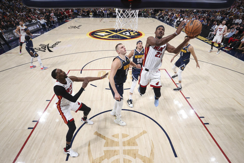 El alero del Heat de Miami Jimmy Butler lanza el balón superando al pívot de los Nuggets de Denver Nikola Jokic en el juego 2 de las Finales de la NBA el domingo 4 de junio del 2023. (Matthew Stockman/Pool Photo via AP)