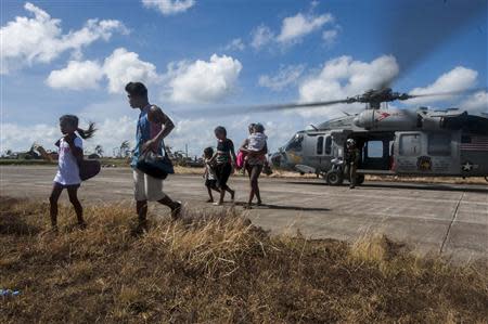 Civilians exit a Sea Hawk helicopter from the Golden Falcons of Helicopter Sea Combat Squadron after being airlifted from an area of the Philippines affected by Typhoon Haiyan in Eastern Samar, Philippines in this November 15, 2013 picture provided by the U.S. Navy. REUTERS/U.S. Navy/Mass Communication Specialist Seaman Liam Kennedy/Handout via Reuters