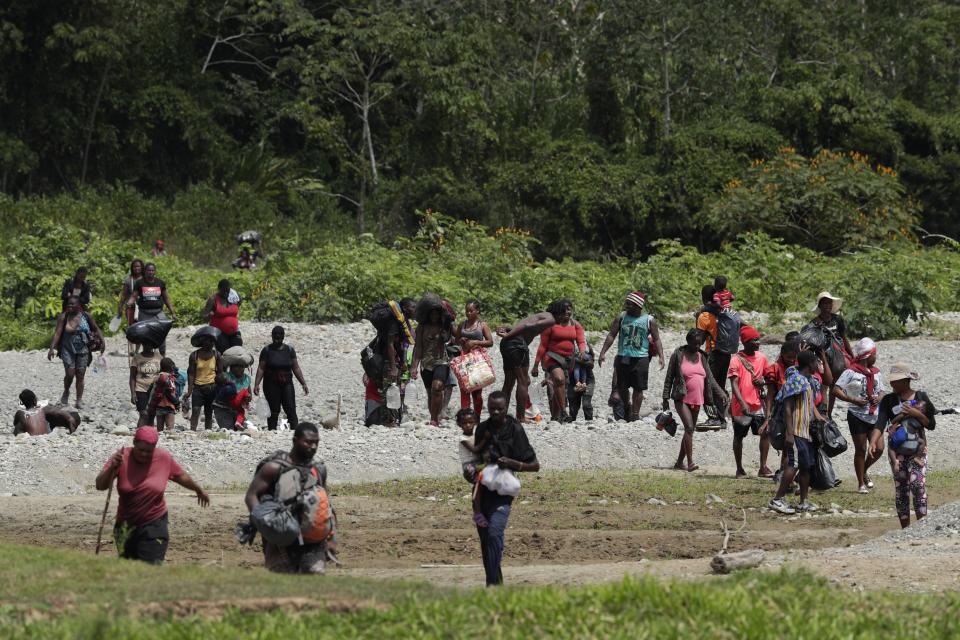 Haitian migrants cross the Tuquesa river after a trip on foot through the jungle to Bajo Chiquito, Darien province, Panama, Wednesday, Feb. 10, 2021. After nearly a year stalled in migrant camps at the edge of the jungle, hundreds of migrants have begun to move across Panama and into neighboring Costa Rica in recent weeks. (AP Photo/Arnulfo Franco)