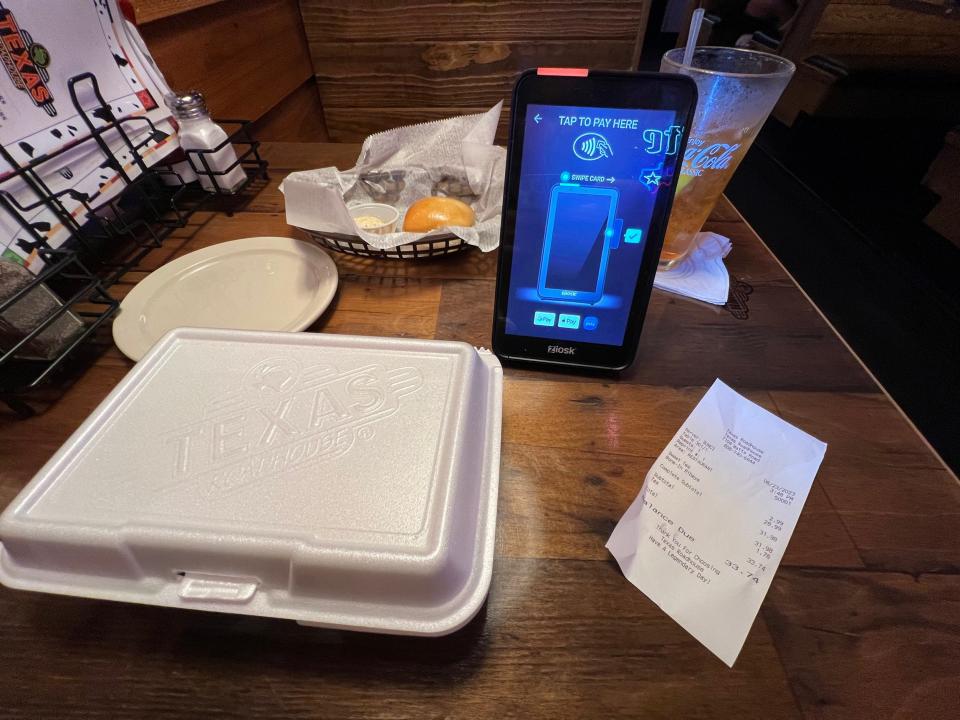 A to-go box and electronic payment device at a Texas Roadhouse