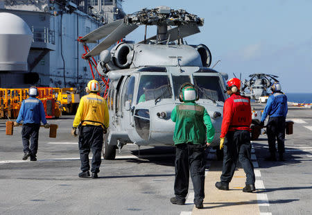 Crew aboard the USS Kearsarge wear different color uniforms to identify their role on the flight deck as the vessel evacuates military personnel from the U.S. Virgin Islands in advance of Hurricane Maria, in the Caribbean Sea near the islands September 18, 2017. REUTERS/Jonathan Drake