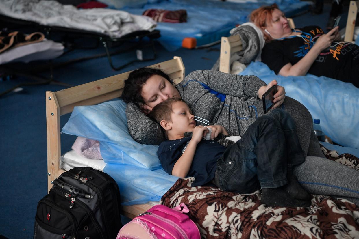 A woman watches a video with her son in a temporary shelter in a gym of a high school in Przemysl, near the Ukrainian-Polish border, on March 15, 2022. - More than three million people have now fled Ukraine since Russia invaded on February 24, the United Nations said on March 15, 2022. (Photo by Louisa GOULIAMAKI / AFP) (Photo by LOUISA GOULIAMAKI/AFP via Getty Images)