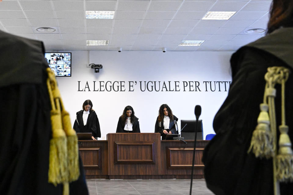 President of the court judge Brigida Cavasino, center, flanked by judges Claudia Caputo, left, and Germana Radice, reads the verdicts of a maxi-trial of hundreds of people accused of membership in Italy's 'ndrangheta organized crime syndicate, one of the world's most powerful, extensive and wealthy drug-trafficking groups, in Lamezia Terme, southern Italy, Monday, Nov. 20, 2023. Verdicts are expected Monday for the trial that started almost three years ago in the southern Calabria region, where the mob organization was originally based. (AP Photo/Valeria Ferraro)