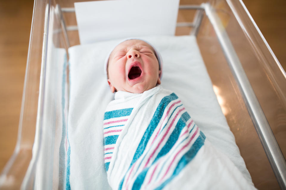 baby yawning in hospital bed
