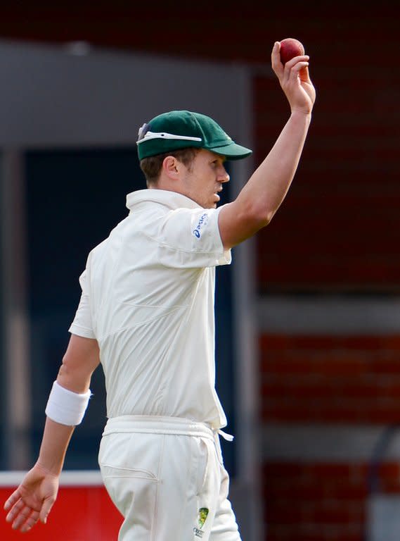 Australia's paceman Peter Siddle raises the ball after taking five Sri Lankan wickets on the third day of their first cricket Test match in Hobart, on December 16, 2012