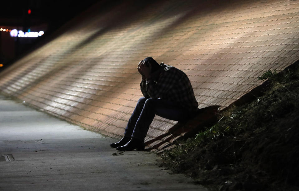 A man holds his head in his hands outside the bar following the shooting. Source: AAP