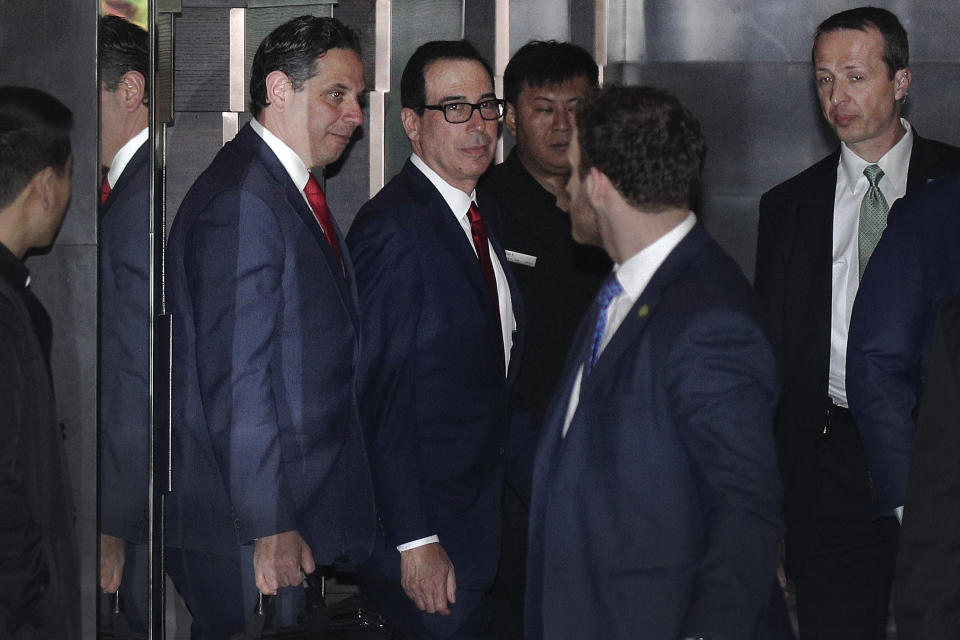 U.S. Treasury Secretary Steven Mnuchin, center, is escorted by bodyguards and a delegation leaves a hotel in Beijing, Friday, March 29, 2019. U.S. trade negotiators lead by Mnuchin and Trade Representative Robert Lighthizer arrived in Beijing to start a new round of talks aimed at ending a tariff war over China's technology ambitions as officials hint they might be making progress. (AP Photo/Andy Wong)