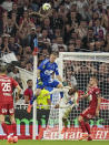 Lyon's Alexandre Lacazette, center, if fouled by Brest's goalkeeper Marco Bizot, top, during a French League One soccer match between Lyon and Brest at the Groupama stadium, outside Lyon, France, Sunday, April 14, 2024. (AP Photo/Laurent Cipriani)