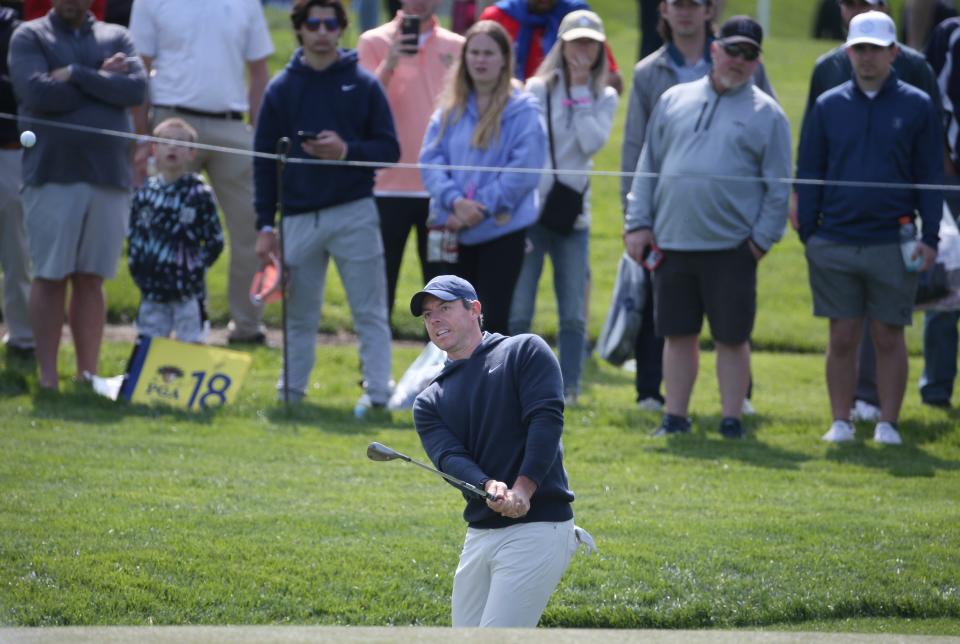 All eyes in the gallery are on Rory McIlroy as he chips onto the green on the second hole during a practice round at the PGA Championship at Oak Hill Country Club Monday, May 15, 2023. 