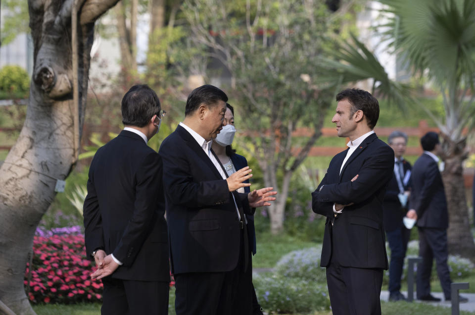 Chinese President Xi Jinping, second left, and French President Emmanuel Macron talk in the garden of the Guandong province governor's residence, in Guangzhou, China, Friday, April 7, 2023. (Jacques Witt, Pool via AP)