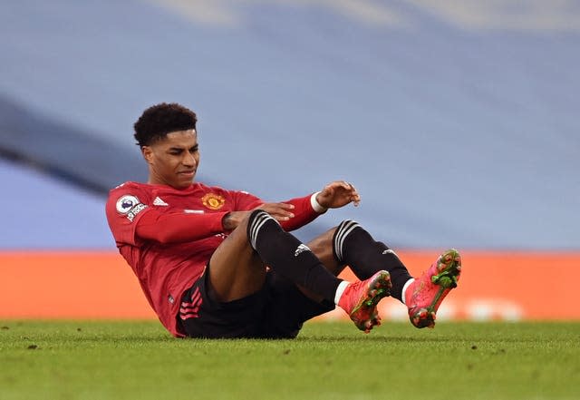 Marcus Rashford sits on the grass injured