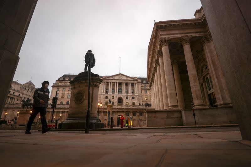 A pedestrian walks past the Bank of England, in London