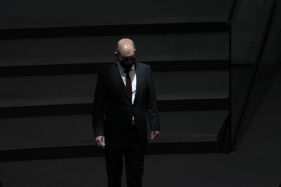 German Chancellor Olaf Scholz walks through the plenary hall at the parliament Bundestag during a debate about a vaccination mandatory in Germany at the Reichstag building in Berlin, Germany, Thursday, April 7, 2022. (AP Photo/Markus Schreiber)