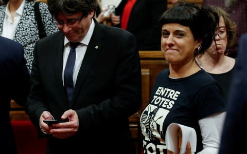 Anna Gabriel pictured last year in the Catalan regional parliament in Barcelona, Spain, next to Catalan Presiednt Carles Puigdemont, who is also in exile in Belgium  - Credit: Albert Gea/Reuters