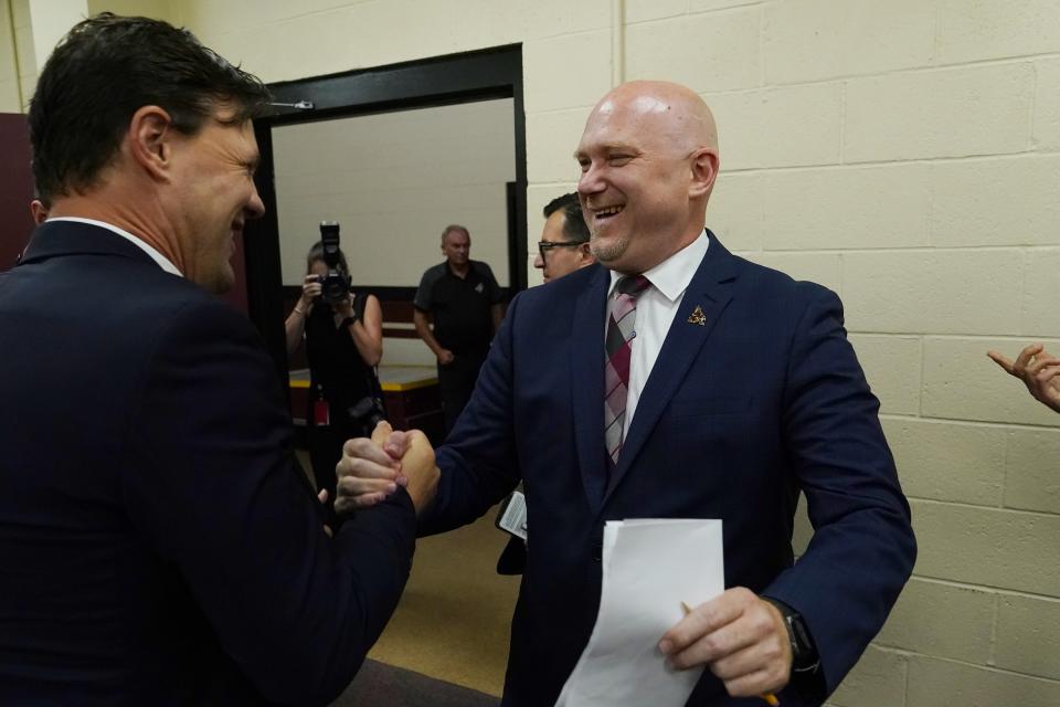 The Arizona Coyotes chief hockey development officer Shane Doan, left, greets new head coach Andre Tourigny, right, after a news conference at Gila River Arena Thursday, July 1, 2021, in Glendale, Ariz. (AP Photo/Ross D. Franklin)