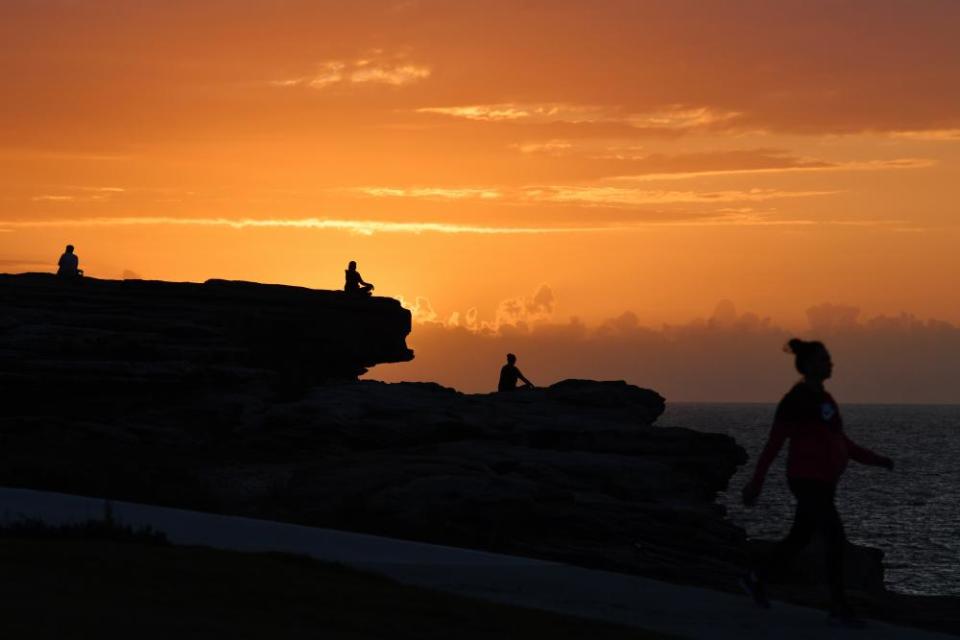 The sun rises as Sydneysiders practise social distancing in Maroubra.