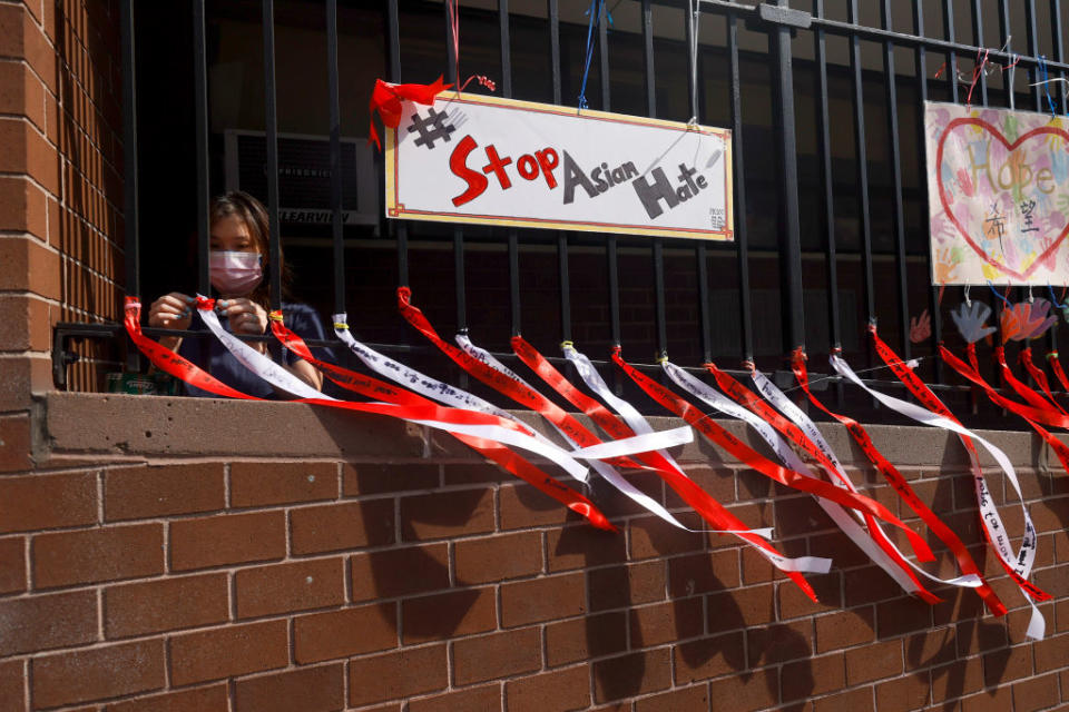 May 2, 2021: Parent Coordinator Christina Pun puts up ribbons with messages of peace, love and hope in front of Yung Wing School P.S. 124 in New York City. May is Asian/Pacific American Heritage month and awareness has spiked due to incidents of Asian racism and other acts of hatred in the age of COVID-19. Schools across the Lower East Side held rallies in response to the violence against the AAPI community. (Michael Loccisano / Getty Images)