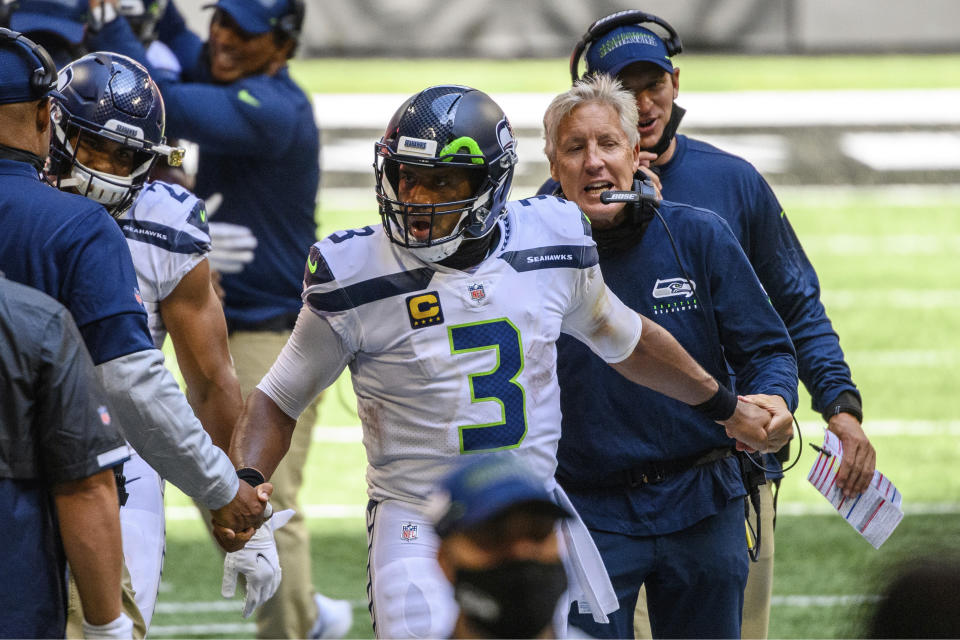 FILE- In this Sunday, Sept. 13, 2020, file photo, Seattle Seahawks head coach Pete Carroll, right, shakes hands with quarterback Russell Wilson (3) on the sideline during the second half of an NFL football game against the Atlanta Falcons in Atlanta. The= Seahawks have had a nasty habit of starting slowly. If their debut at Atlanta last weekend is any indication, Carroll and Wilson have the motors revving from the jump. (AP Photo/Danny Karnik, File)