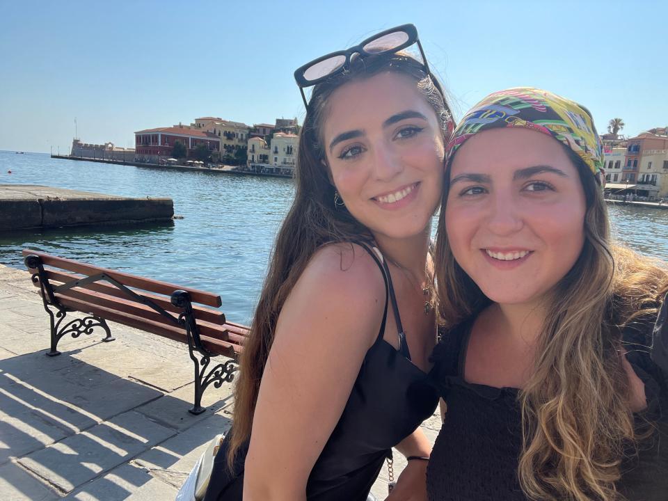 rachel and her sister posing in front of the water while docked on their regent seven seas explorer cruise