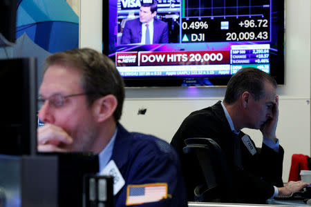 Traders work on the floor of the New York Stock Exchange (NYSE) as the Dow Jones Industrial Average passes the 20,000 mark shortly after the opening of the trading session in New York, U.S., January 25, 2017. REUTERS/Brendan McDermid